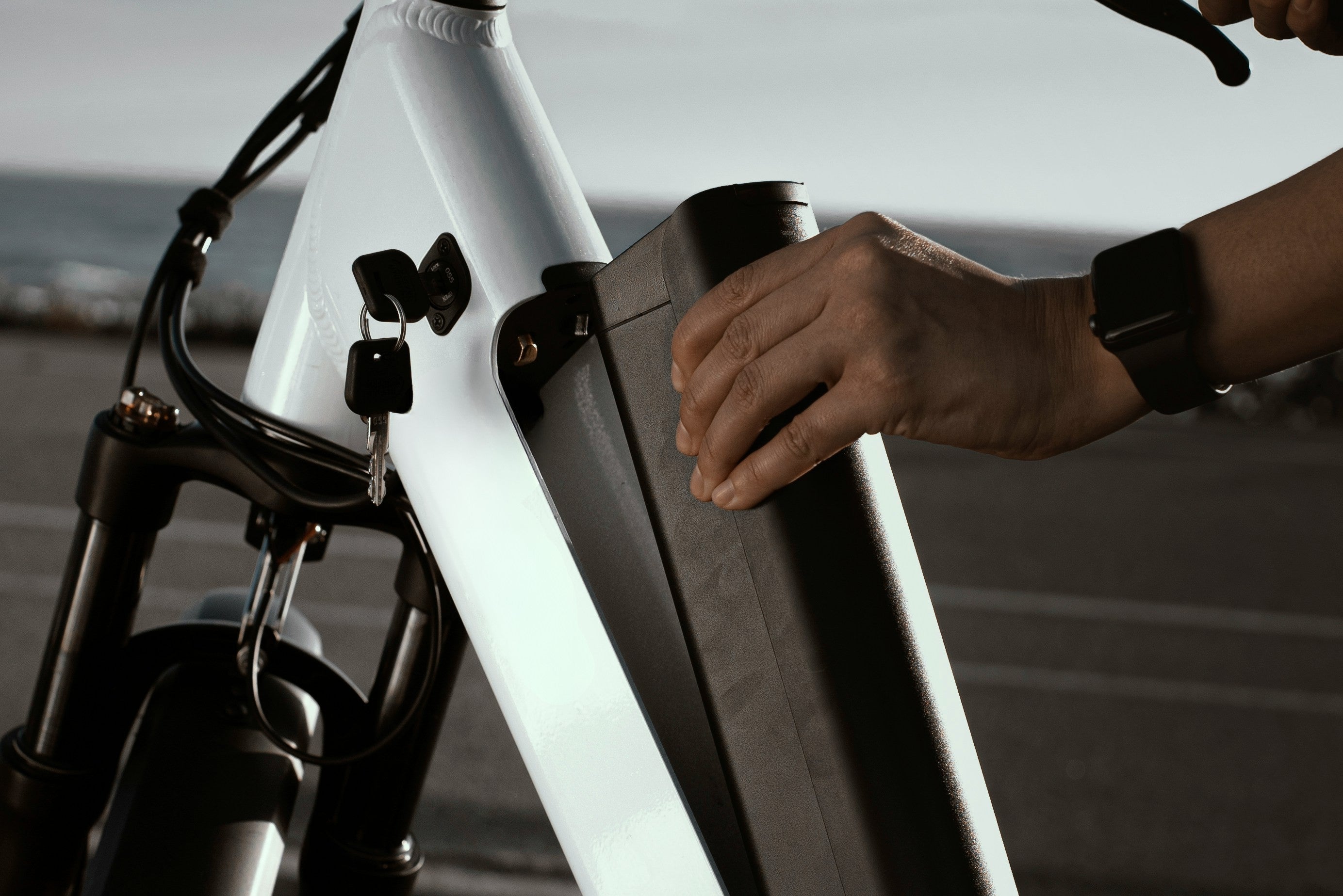 Cyclist removing the battery from an electric bike before cleaning